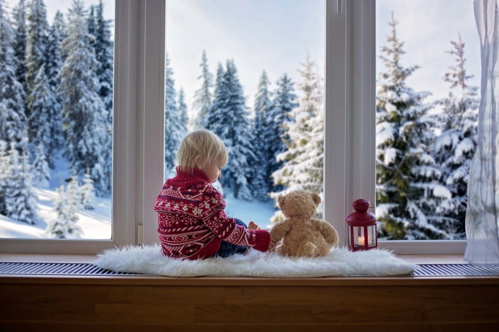 Wärmedämmung - Kind mit Teddy vor Fenster mit Isolierverglasung
